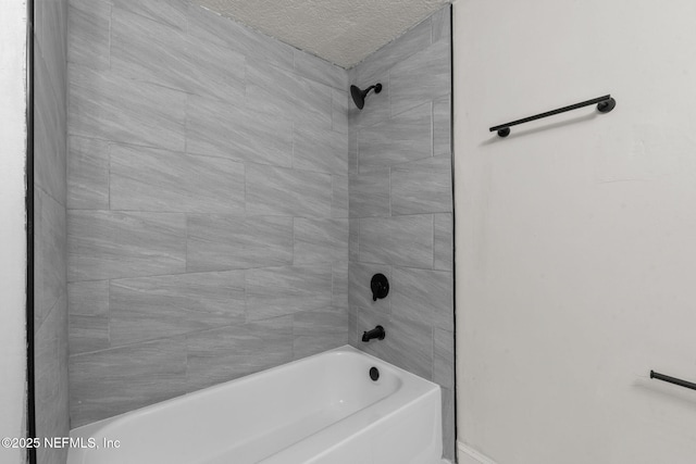 bathroom featuring tiled shower / bath and a textured ceiling