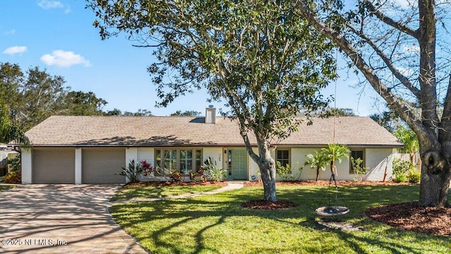 ranch-style home with a garage and a front lawn