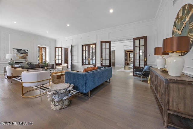 living room with french doors, dark wood-type flooring, and crown molding