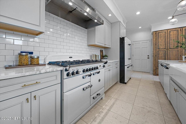 kitchen with white cabinetry, ventilation hood, ornamental molding, and high end fridge