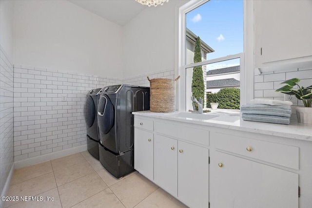 washroom featuring cabinets, sink, washer and dryer, and light tile patterned flooring