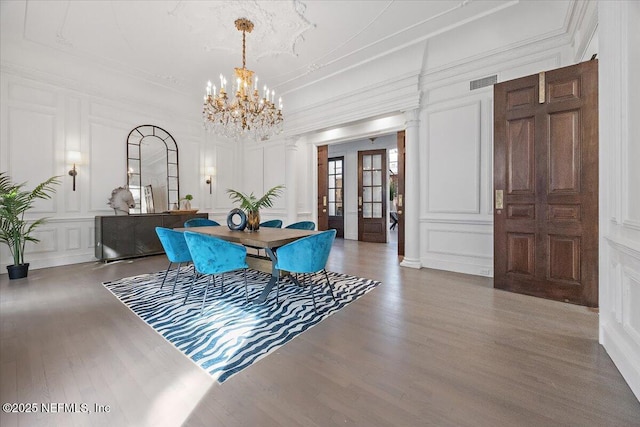 dining area with wood-type flooring and an inviting chandelier