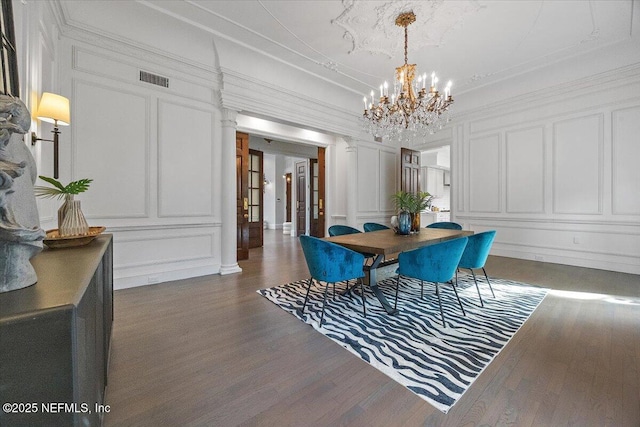 dining area with dark hardwood / wood-style flooring and an inviting chandelier