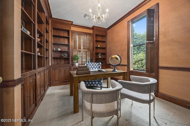 carpeted home office with built in shelves, crown molding, and a chandelier