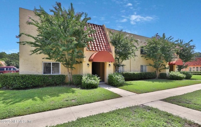 mediterranean / spanish-style house featuring a front lawn