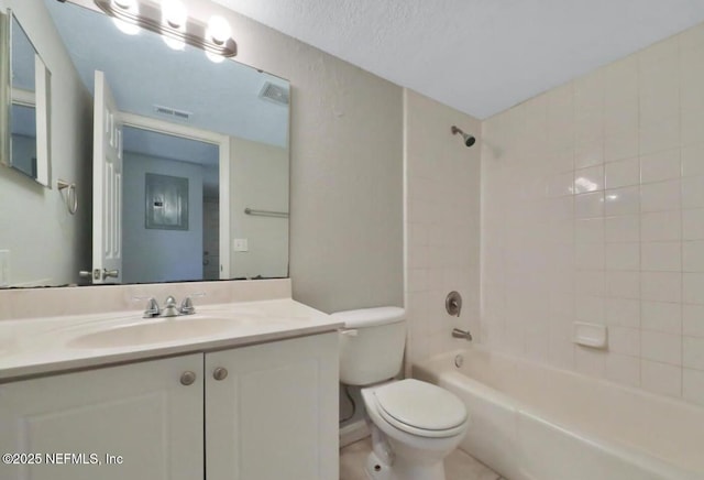 full bathroom featuring toilet, tiled shower / bath, tile patterned flooring, vanity, and a textured ceiling