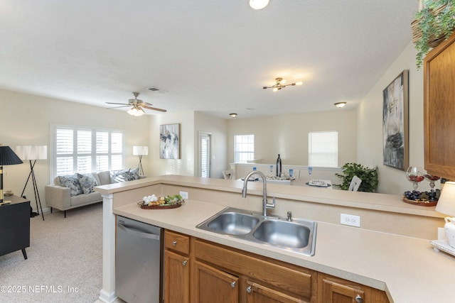 kitchen with sink, light colored carpet, dishwasher, and ceiling fan