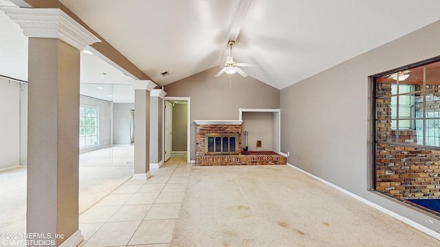 unfurnished living room with vaulted ceiling, ceiling fan, ornate columns, light tile patterned floors, and a fireplace