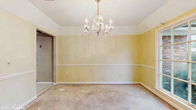 spare room with a healthy amount of sunlight and a notable chandelier