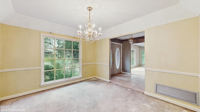 empty room featuring an inviting chandelier and a tray ceiling