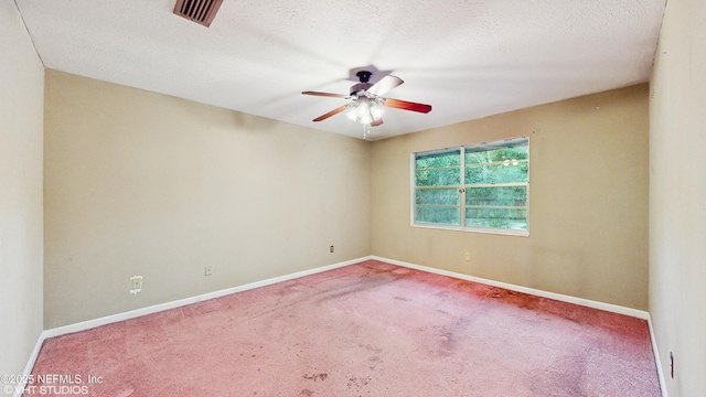 carpeted spare room with a textured ceiling and ceiling fan