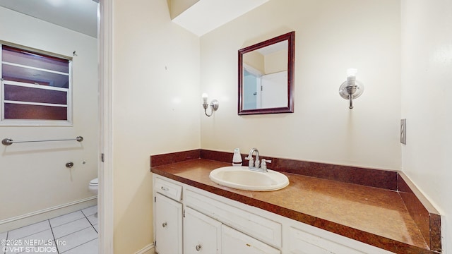 bathroom featuring toilet, vanity, and tile patterned flooring