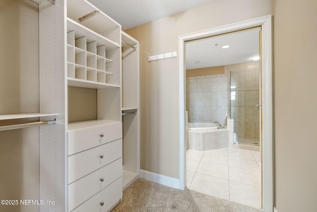 walk in closet with light tile patterned floors