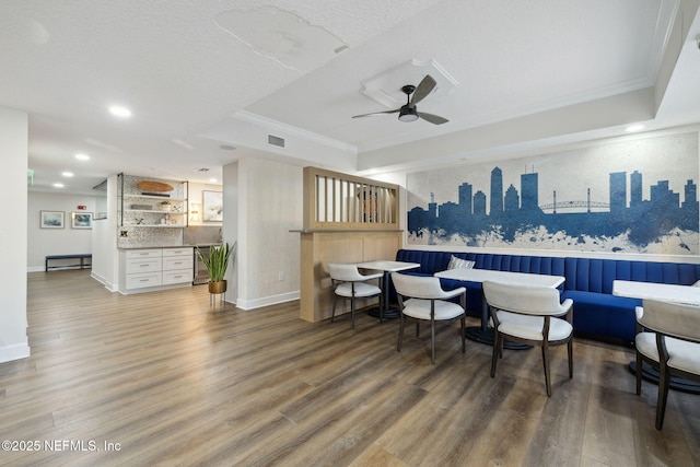 interior space featuring crown molding, white cabinets, ceiling fan, hardwood / wood-style floors, and backsplash