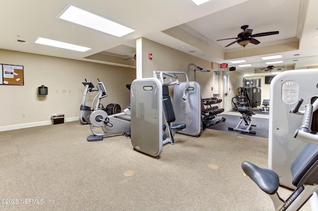 gym featuring crown molding, light colored carpet, ceiling fan, and a tray ceiling