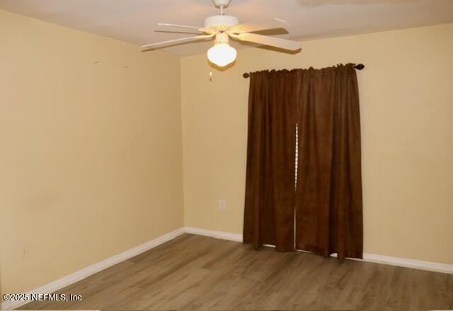 empty room featuring dark wood-type flooring and ceiling fan