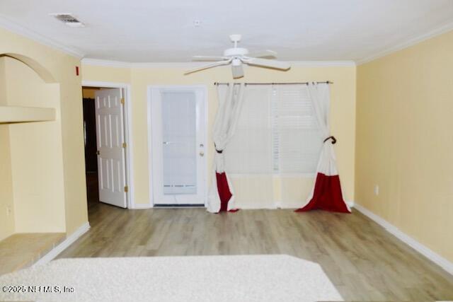 unfurnished room with crown molding, light hardwood / wood-style floors, and ceiling fan