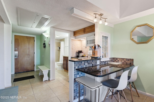 dining room featuring visible vents, light tile patterned flooring, a textured ceiling, and baseboards