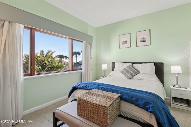 bedroom with light tile patterned floors and baseboards