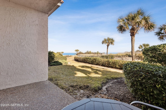 view of yard featuring a water view and fence