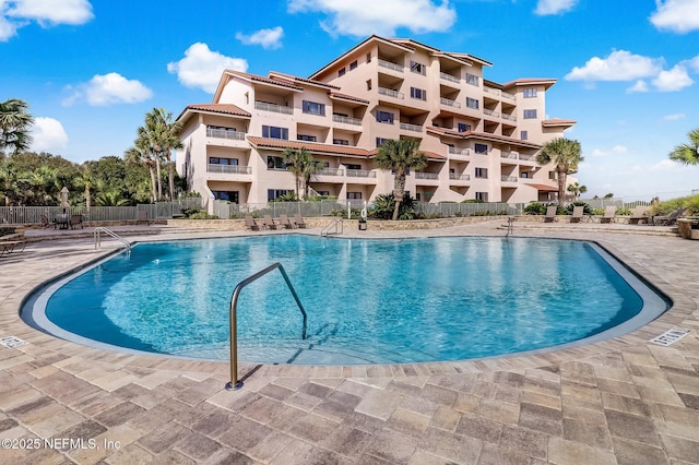 community pool featuring a patio area and fence