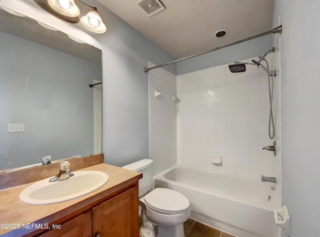 full bathroom with a textured ceiling, tile patterned flooring, washtub / shower combination, vanity, and toilet