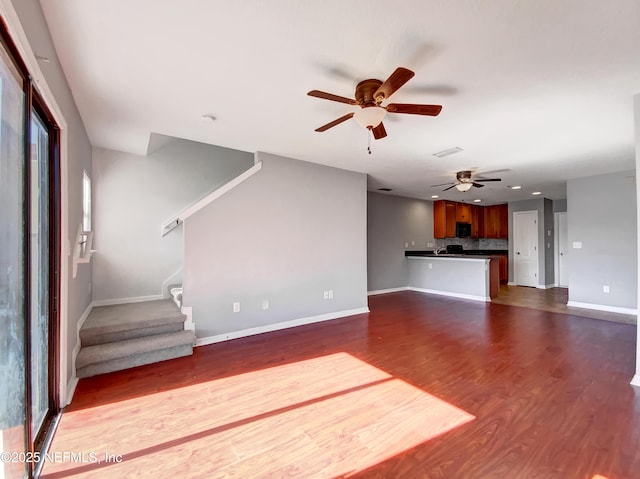 unfurnished living room with dark wood-type flooring and ceiling fan