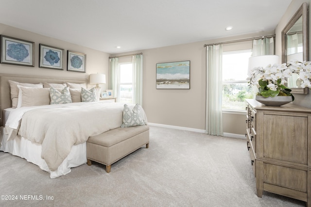 carpeted bedroom featuring multiple windows