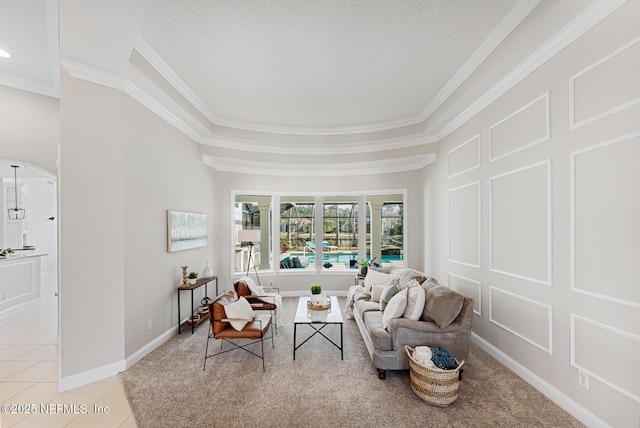 living area featuring light tile patterned floors, baseboards, ornamental molding, and a decorative wall