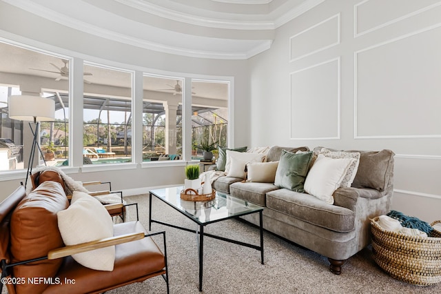 carpeted living area with crown molding, ceiling fan, a sunroom, and a decorative wall