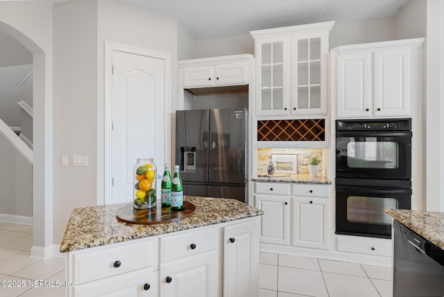 kitchen featuring black appliances, a kitchen island, glass insert cabinets, and white cabinets