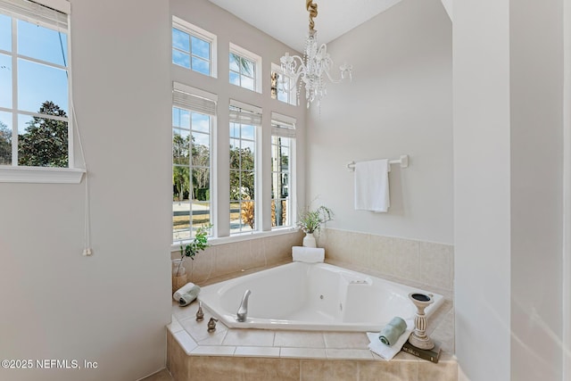 full bath with a garden tub and an inviting chandelier