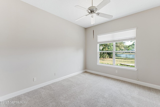 carpeted empty room with ceiling fan and baseboards