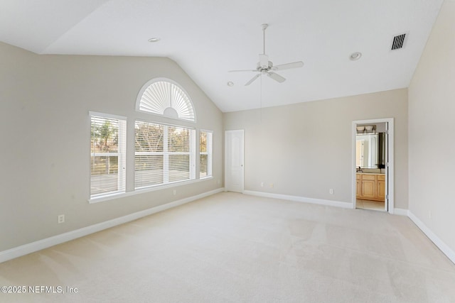 spare room featuring visible vents, a ceiling fan, light carpet, high vaulted ceiling, and baseboards