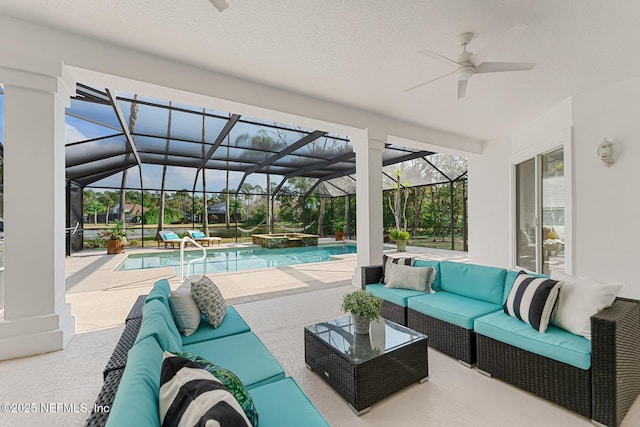 view of patio / terrace featuring a lanai, a pool with connected hot tub, and an outdoor living space