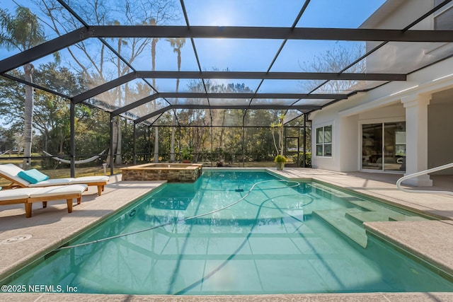 view of swimming pool with glass enclosure, a patio area, and a pool with connected hot tub