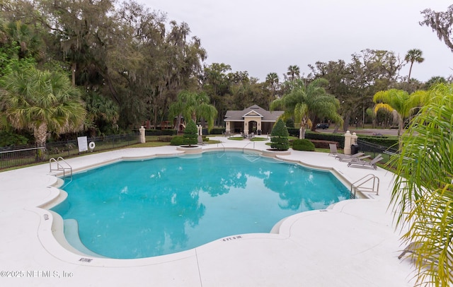 pool featuring fence and a patio