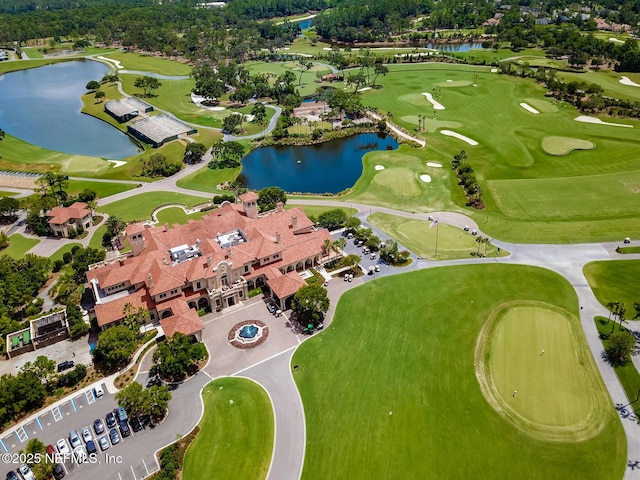 aerial view with golf course view and a water view