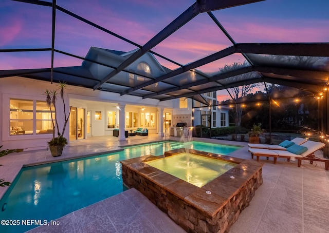 pool at dusk with a lanai, a pool with connected hot tub, and a patio