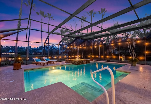 pool with glass enclosure, a patio area, and an in ground hot tub