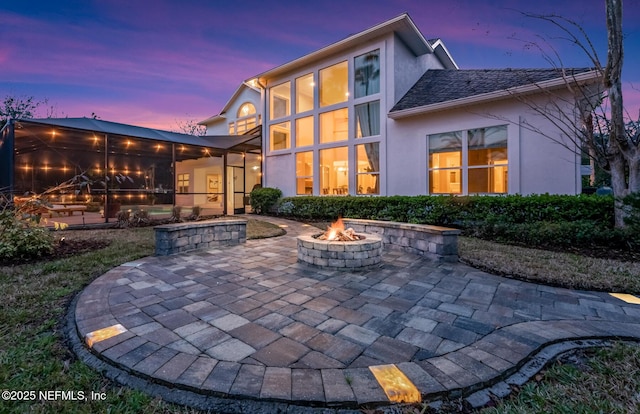 back of property featuring a patio area, an outdoor fire pit, and stucco siding