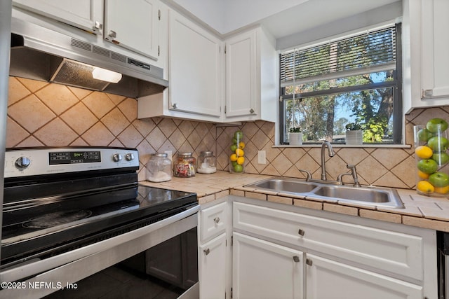 kitchen with tile countertops, white cabinets, electric range, and sink