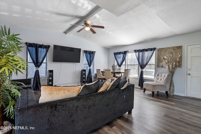 living room with ceiling fan, lofted ceiling with beams, dark wood-type flooring, and a textured ceiling