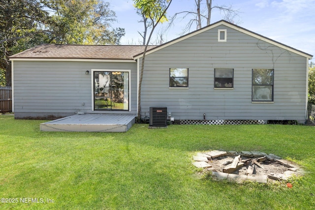 rear view of property with a deck, an outdoor fire pit, a lawn, and central air condition unit