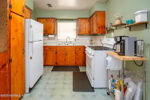 kitchen with decorative backsplash, sink, and white appliances