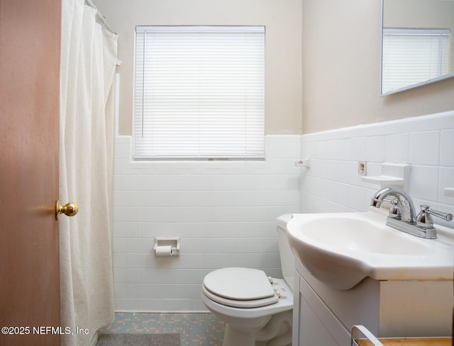 bathroom featuring toilet, vanity, tile walls, and tile patterned floors