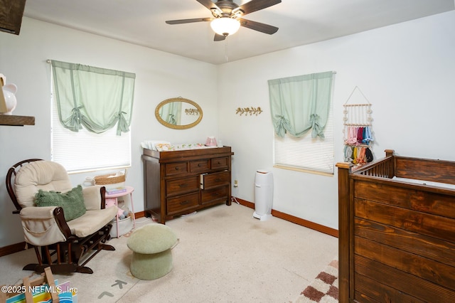 bedroom featuring ceiling fan and a crib