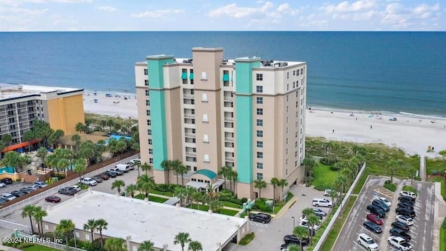 drone / aerial view featuring a water view and a view of the beach