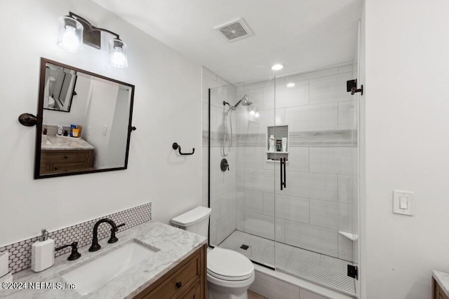 bathroom with toilet, vanity, and walk in shower