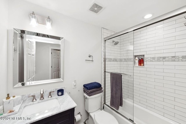 full bathroom featuring vanity, toilet, and combined bath / shower with glass door